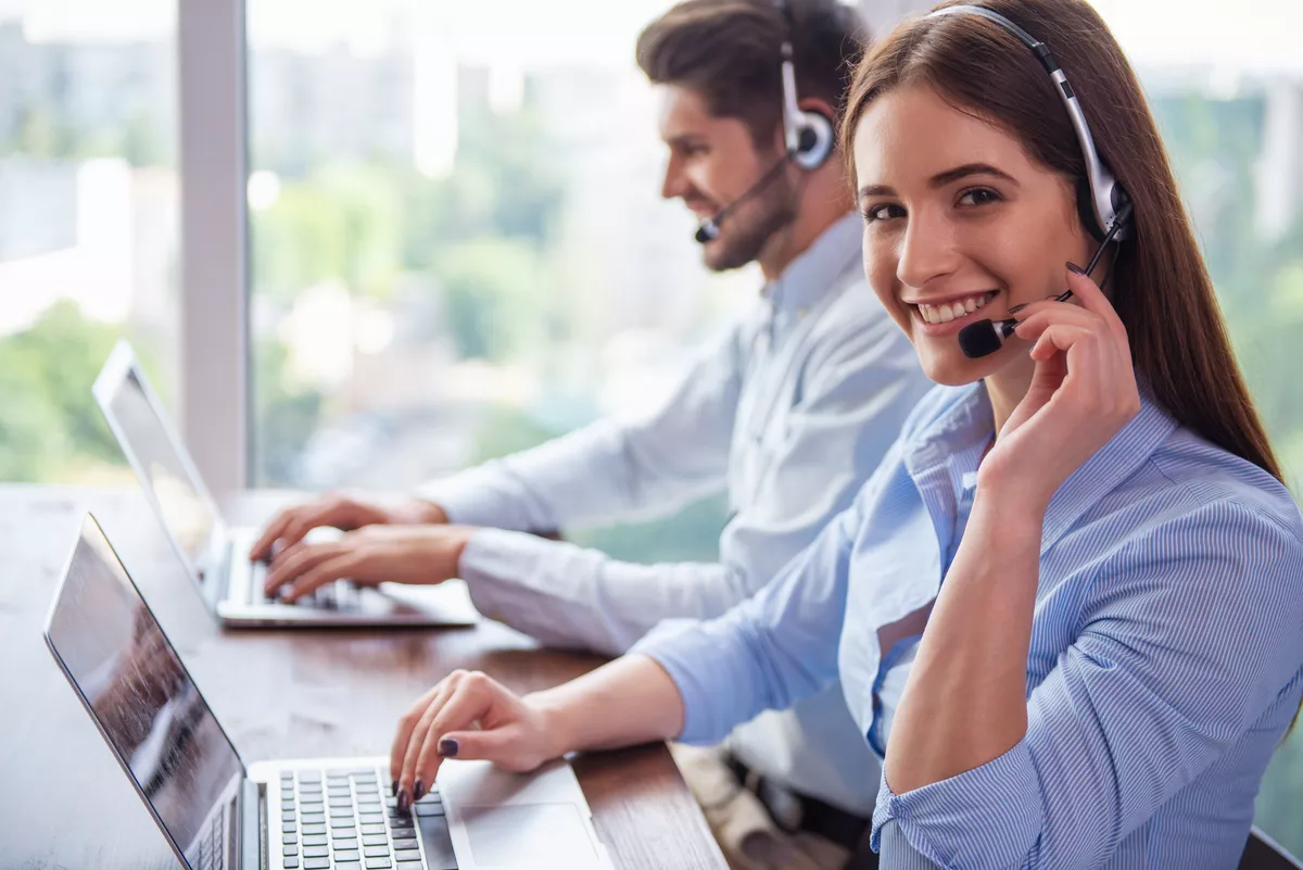 A friendly customer support and dispatch team wearing headsets in a bright Durham, NC office, coordinating HVAC service calls.